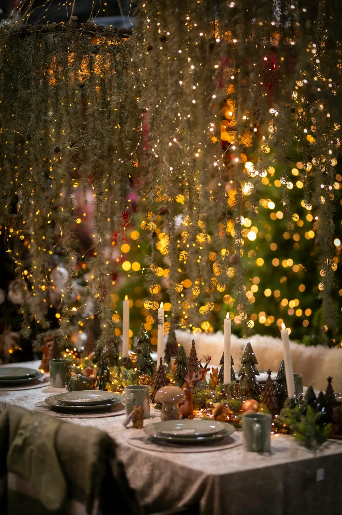 A long table set for a festive meal under hanging lights