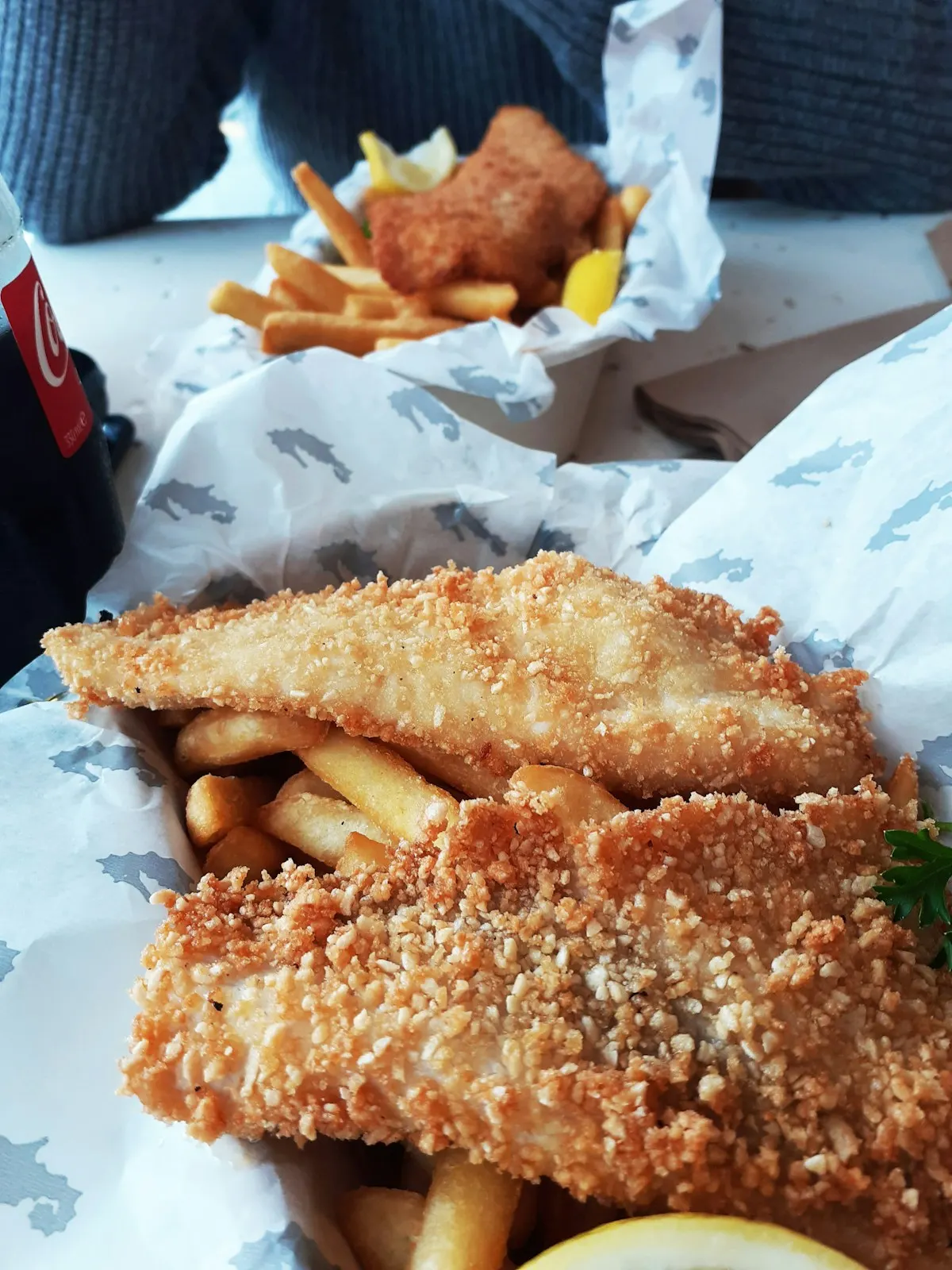 Fish and chips served on printed paper